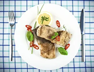 Studio Shot Meal Drucke: Fried fish on white plate and fork