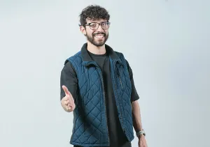 Attractive Young Man Image Drucke: Friendly handsome guy greets you with open hand isolated