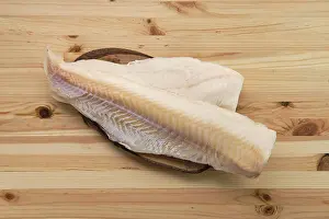 Drucke von Gefrorenes Karpfenfilet auf Holztisch Kabeljau Im Atlantik Drucke: Gefrorener Fischfilet aus Kabeljau auf Holztisch.