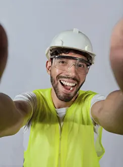 Construction Worker Photo Drucke: Funny builder engineer taking a selfie isolated