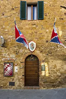 Drucke von Tor eines alten Gebäudes mit Flaggen und Werbeplakat, Montisi, Provinz Siena, Toskana-Region, Italien Poster Drucke: Tor eines alten Gebäudes mit Fahnen und Werbeplakat.
