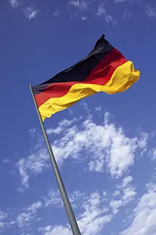 European National Flags Drucke: German flag on flagpole flapping in the wind in front of a blue sky