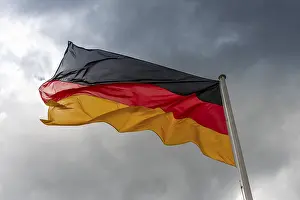 Symbolic National Colours Drucke: Germany flag in the wind in front of dark clouds