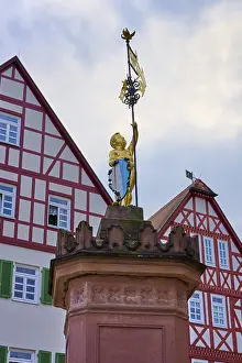 Historic German City Square Drucke: Gilded statue in front of half-timbered architecture