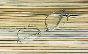 Magazine Stack Drucke: Glasses on the background of the stack of magazines