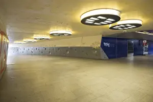 Drucke von Dunkler Unterführungsbauwerk auf dem Wiener Platz in Köln-Mülheim, gekennzeichnet durch kalten Beton, kreisförmige Wandstrukturen und gelblichem Deckenlicht Zeitgenössische Kunst Drucke: Dunkler Unterführungsbauwerk auf dem Wiener Platz in Köln-Mülheim.