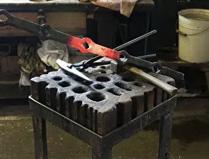 Metal Workshop Drucke: Glowing workpiece on the workbench in a forge