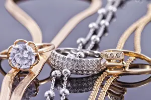 Reflective Surface Drucke: Gold ring, earrings and chains on a reflective surface
