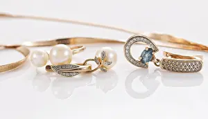 Semi Precious Stones Drucke: Gold ring, earrings and chains on a reflective surface