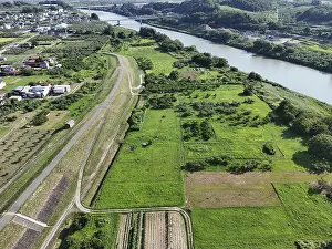 River Landscape Drucke: A green field with a river running through it