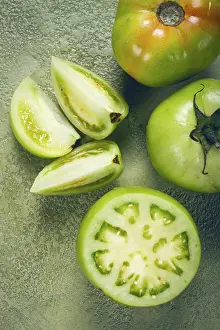 Raw Vegetables Drucke: Green tomatoes, sliced on the table