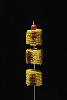 Corn Still Life Photography Drucke: Grilled corn on the corn cob on a skewer