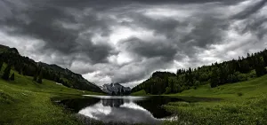 Wildhaus Appenzell Scenery Drucke: Groppelensee with reflection of the Altmann summit in the background under a threatening cloudy sky