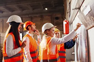 Workplace Communication Skills Drucke: The group of workers stands next by the flip chat and plans work