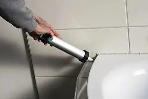 Construction Worker At Site Drucke: Grouting work. Tiler grouting in a new bathroom