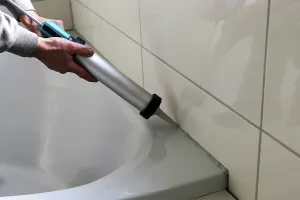 Ceramic Tile Installation Drucke: Grouting work. Tiler grouting in a new bathroom