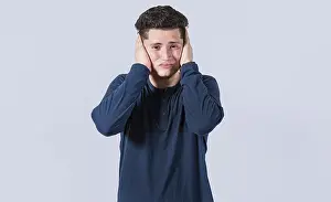 Man Covering Ears Drucke: A guy covering his ears, avoiding hearing