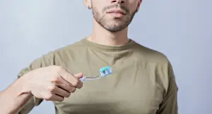 Personal Hygiene Practice Drucke: Guy with unrecognizable face holds brush with toothpaste on isolated background