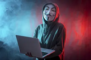 Digital Information Protection Drucke: Hacker with anonymous mask with a computer and with a background of smoke and colored led