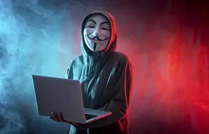 Hacker Anonymous Mask Drucke: Hacker with anonymous mask with a computer and with a background of smoke and colored led