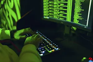Computer Virus Protection Drucke: Hacker in hoodie working hacks code site on personal computer