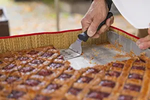 Southern Germany Food Photography Drucke: Hand cut a raspberry pastry with a scraper on a baking tray