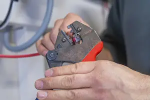 Industrial Craftsman Drucke: Hand holding pliers that process a cable