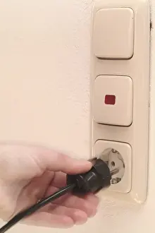 Accident Prevention Tips Drucke: Hand pulls plugs from plug socket