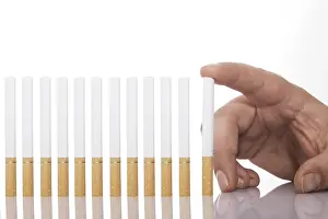 Smoking Addiction Drucke: Hand beside a row of cigarettes