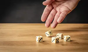Empty Wooden Desk Drucke: Hand throwing five dice on a wooden table