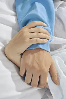 Couple In Bed Drucke: Two hands are held together on bed sheets