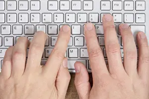 Top Down Perspective Drucke: Hands typing on a computer keyboard