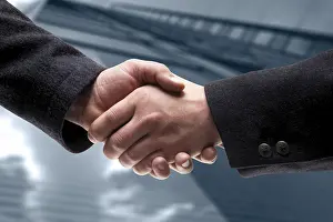 Business Handshake Drucke: Handshake, office tower in background (composing shot)