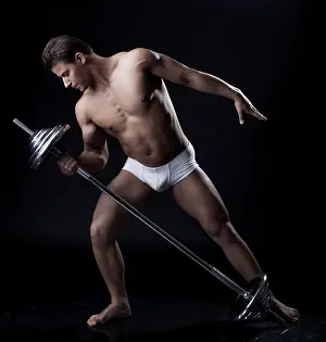 Athletic Training Drucke: Handsome athlete lifting weights in studio