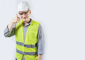 Portrait Photography Drucke: Handsome engineer making call gesture with fingers
