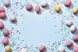 Easter Greeting Card Drucke: Happy easter greeting card. Frame of chocolate eggs in sugar glaze and sugar sprinkling on blue background Flat lay