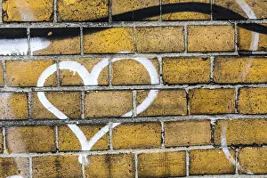 Wandmalereien Drucke: Herzgraffiti auf einer Ziegelmauer.