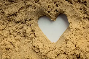Symbolic Heart Image Drucke: Heart shape made on the sand background in view