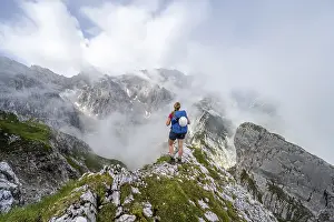 German Hiking Trails Drucke: Hiker looking at mountains under dramatic clouds