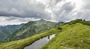 Mountain Lake Reflections Drucke: Hiker is reflected in a small lake