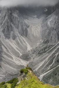 Alpine Landscape Scenery Drucke: Hiker standing on a ridge, dramatic cloudy sky