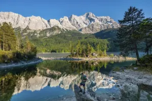 Water Reflection In Mountains Drucke: Hiker standing on rocks, view into the camera