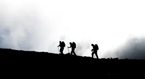 Hiking In Austria Drucke: Three hikers on ridge in backlight