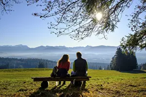High Angle View Of Cityscape Drucke: Hikers taking a break on a bench