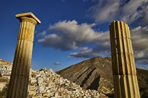 Historic Greek Island Town Drucke: Historic columns frame an old town against a dramatic sky