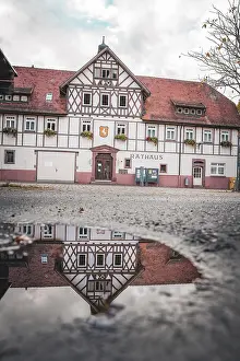 German Historic Quarter Image Drucke: Historic town hall with reflection in puddle
