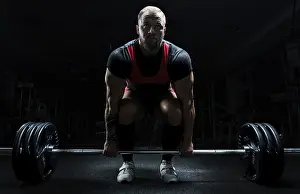 Young Man Gym Drucke: Huge man is preparing to perform an exercise called deadlift