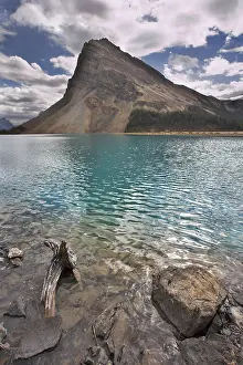 Deserted Waterfront Landscape Drucke: The huge rock of the triangular form is reflected in emerald waters of cold mountain lake
