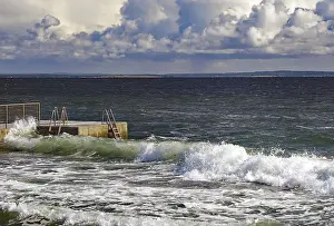 Dramatic Sky Photography Drucke: Huge waves crash against a jetty under a dramatic sky