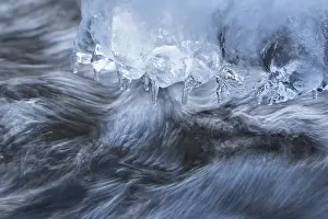 Deserted River Waterfront Drucke: Icicles have formed on a stone in a stream